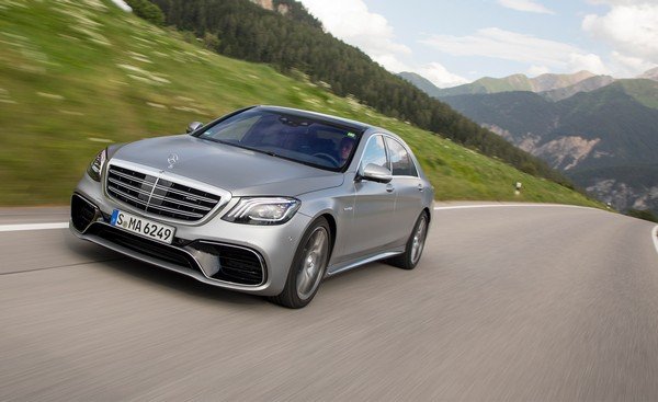 Silver Mercedes-benz S-class 2018 running on road, angular right front view, nature background of trees and mountains 