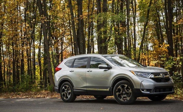 Honda CR-V 2018 parking on road, angular left side view, nature background of trees in autumn