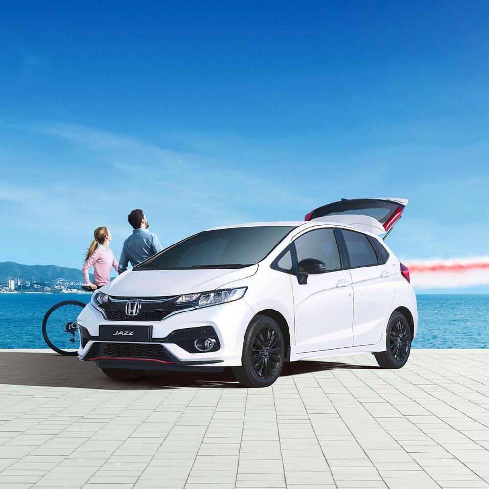 Honda Jazz 2018 white colour park on road front look open trunk sky and ocean background