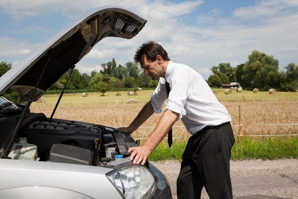 man and car with dead battery, bonnet being opened, back ground of grassland