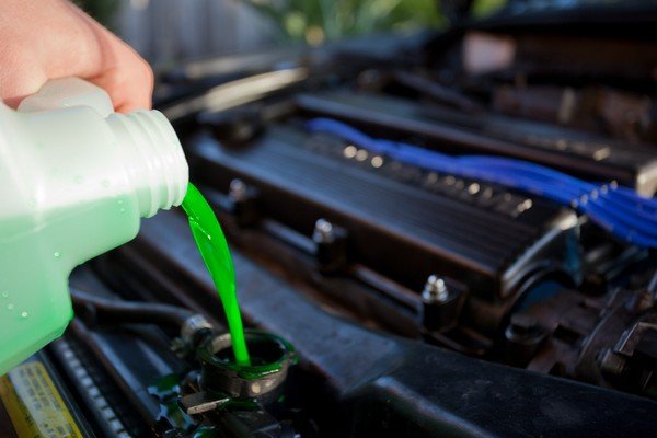 pouring the engine oil and coolant in to the hood