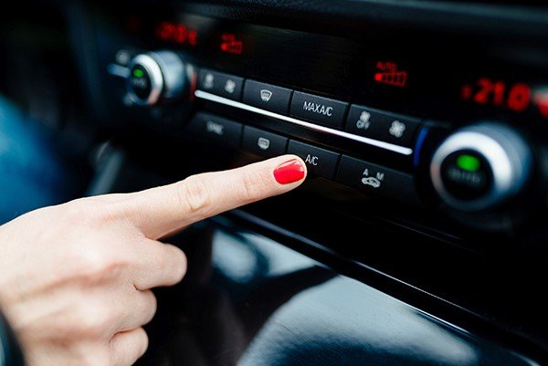 finger putting on the AC controls in a car