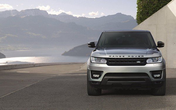 range Rover light silver color ocean background parking on road 