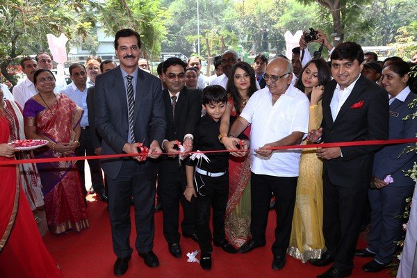 Several adults and one boy cutting the ribbon