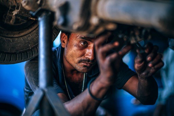A man with two dirty hands fixing a broken car