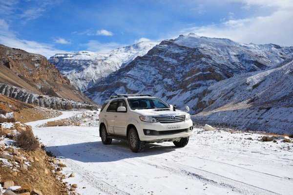 SUV at a mountainous area with mountains and snow