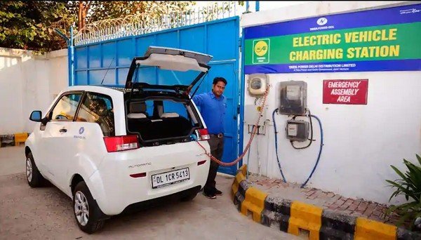 A man charging his car at a public charging station in Mumbai