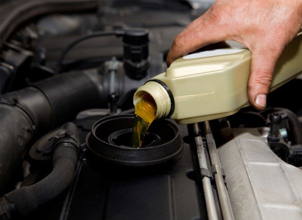 Someone changes the oil in the car