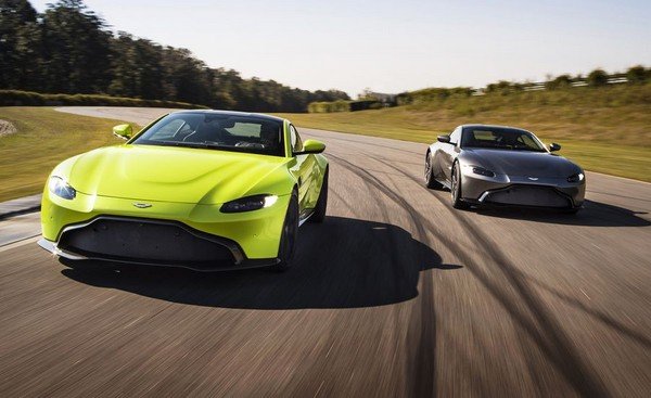 2 Aston Martin cars running on road