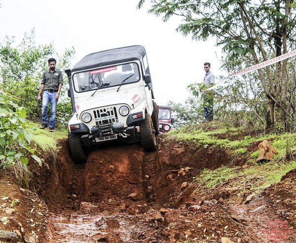 Mahindra white car off-road training with 2 man