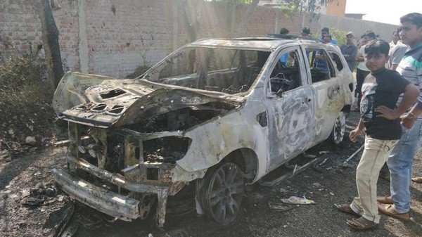 People around the burnt Ford Endeavour