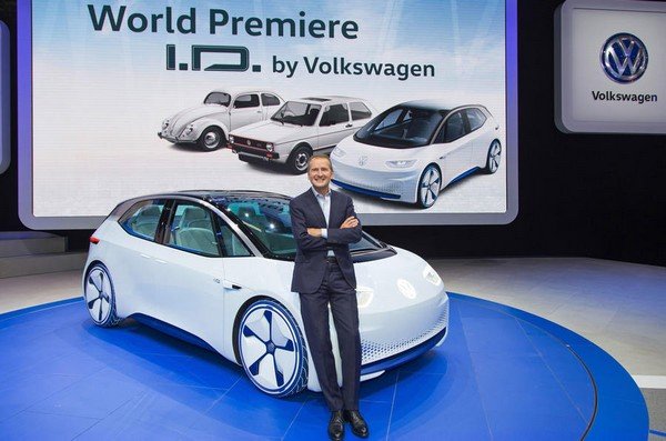 The CEO of Volkswagen Group, Herbert Diess sitting in front of a car