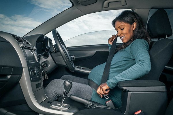 pregnant women wearing seatbelt inside a car 