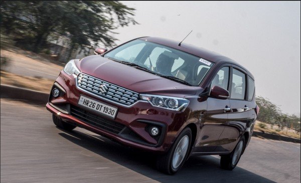 Maruti Ertiga red color running on road front look