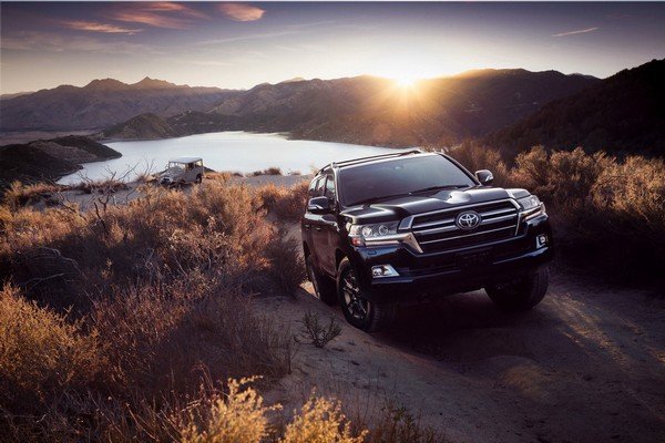 Toyota Land Cruiser parking on shore of lake with nature background