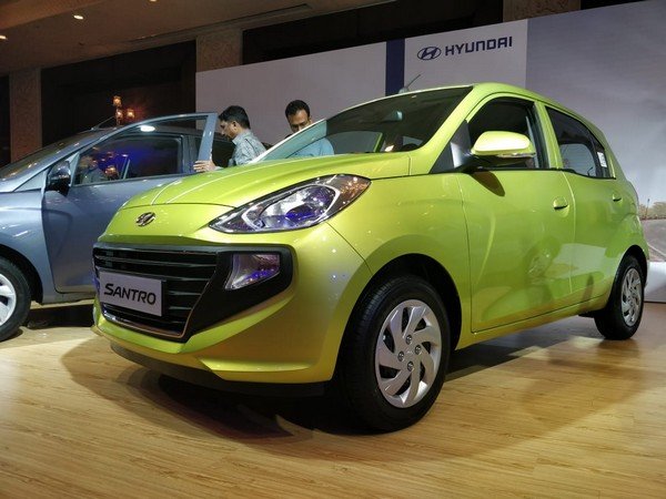 2 Hyundai Santro at show room with zoom in the neon green one