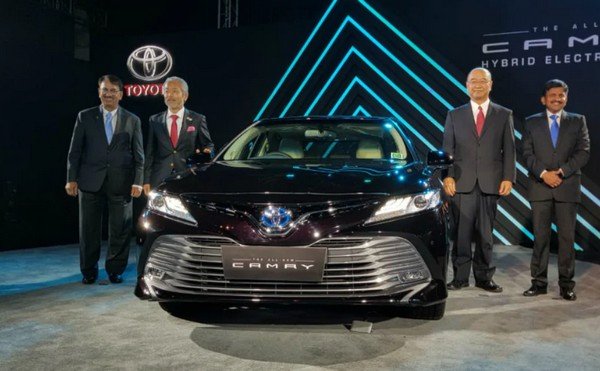 2019 Toyota Camry Hybrid black front in the showroom