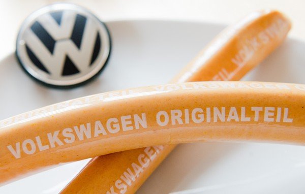 Sausage called Currywurst with a Volkswagen logo in the background 