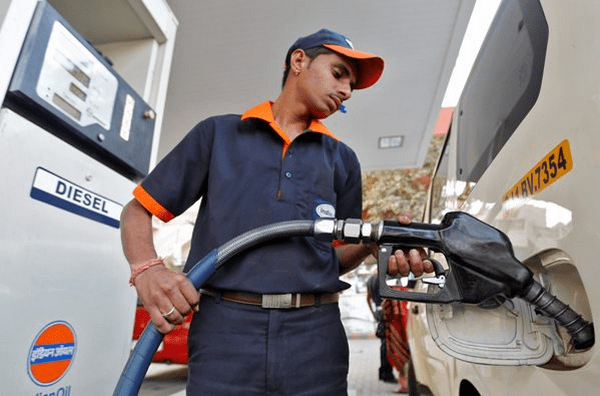 man filling vehicle fuel tank at gas station