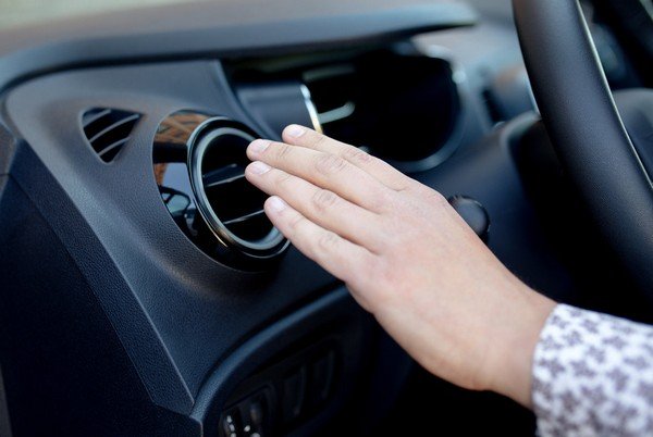 hand on the air conditioner in car