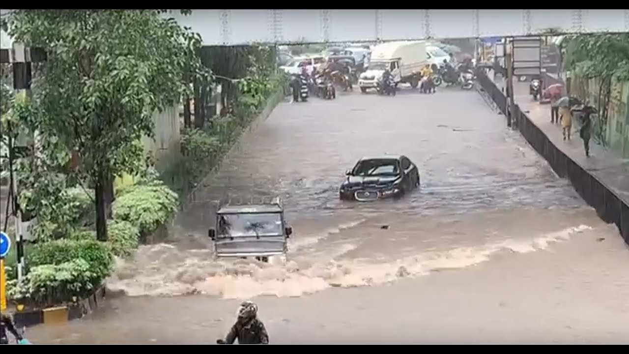 Mahindra Bolero drives past Jaguar stuck in Mumbai floods