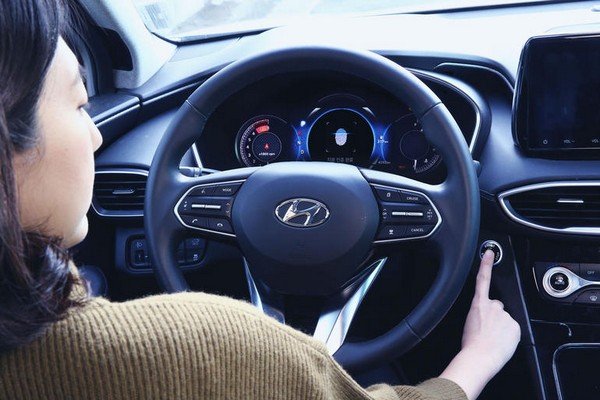 woman putting finger on car start button