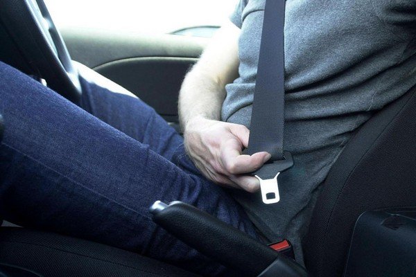 man sitting in a car wearing a seatbelt