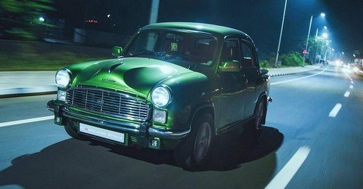 Hindustan Ambassador running on road with headlights on