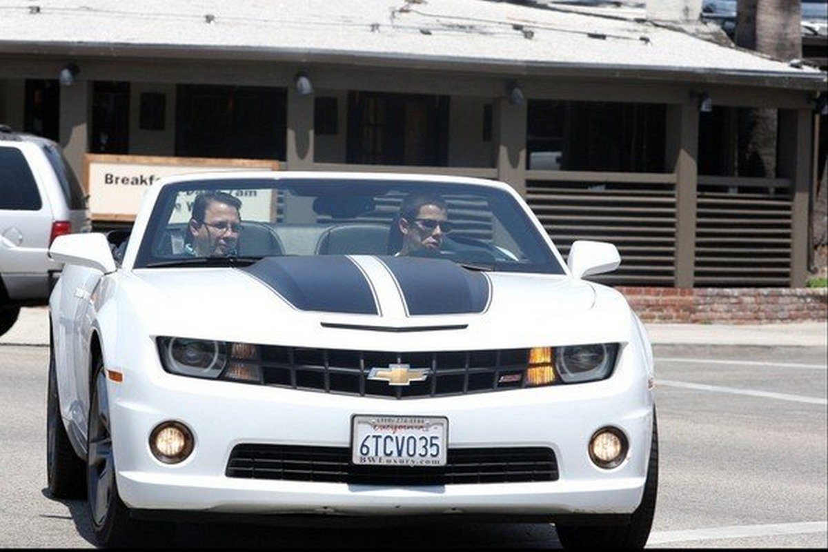 Nick and another man sitting in the white Chevy