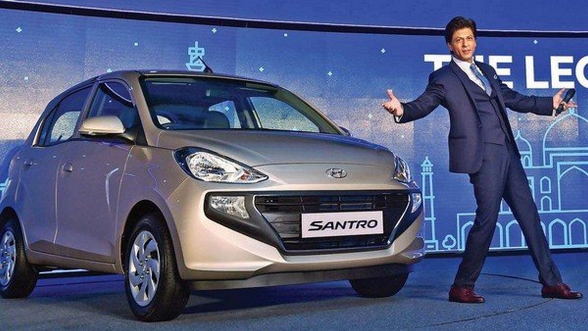 Shah Rukh Khan standing in front of the Hyundai Santro at launch ceremory