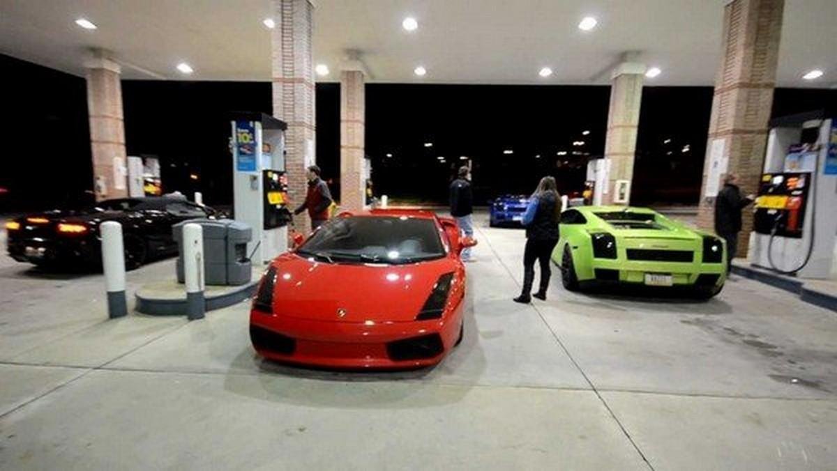  three Lamborghinis in a gas station.