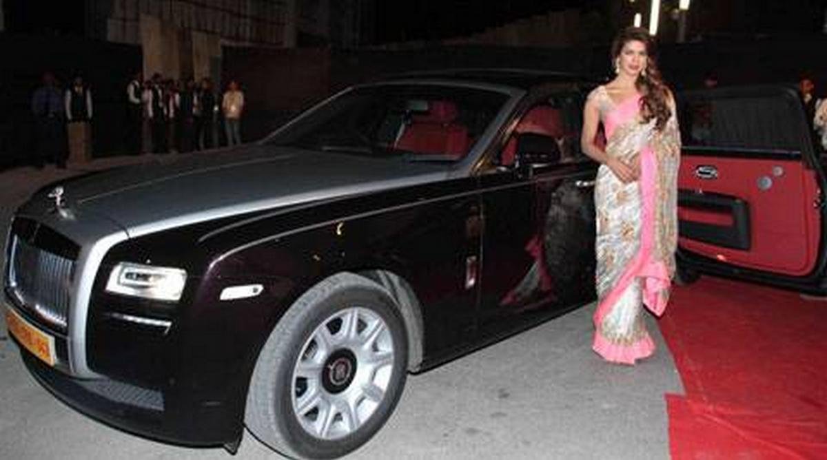 Priyanka Chopra wearing sari standing next to her Rolls-Royce