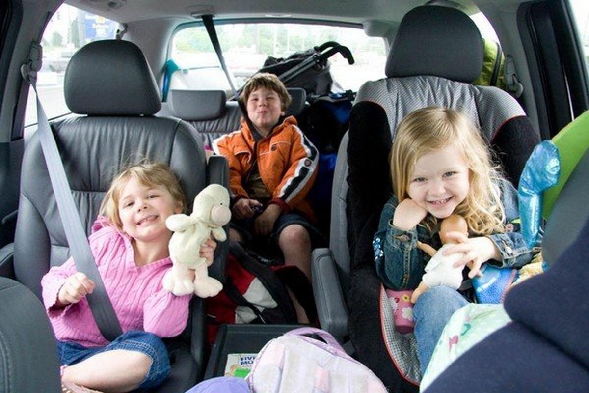 Children playing with toys and eating in car