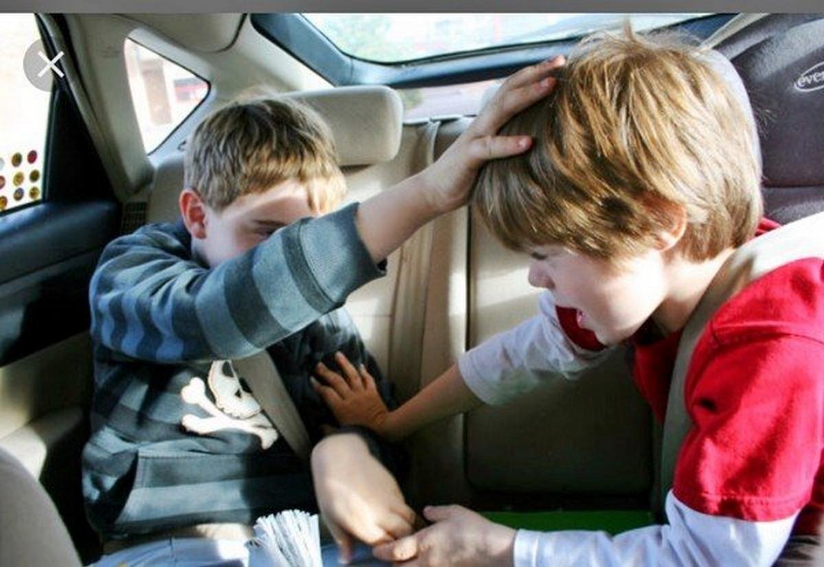 Two boys fighting in the back seats