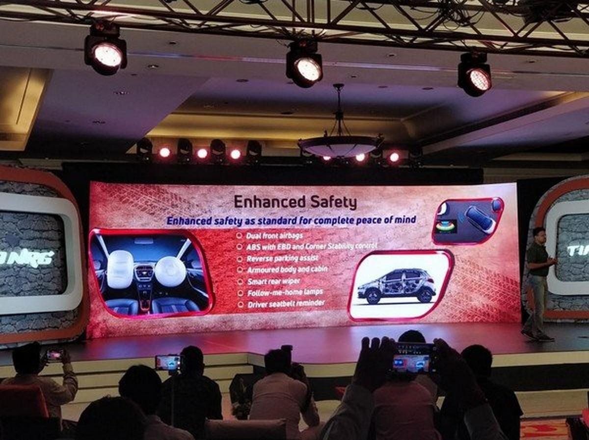Speaker presenting about Tata Tiago NRG's safety features with a slide in the show room