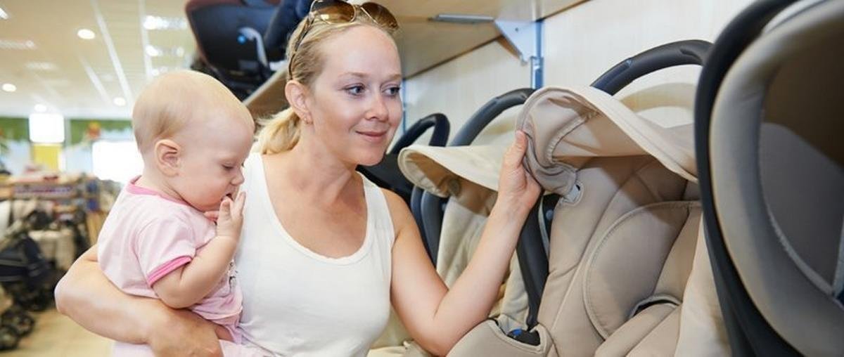 mother-holding-kid-shopping-for-child-safety seat