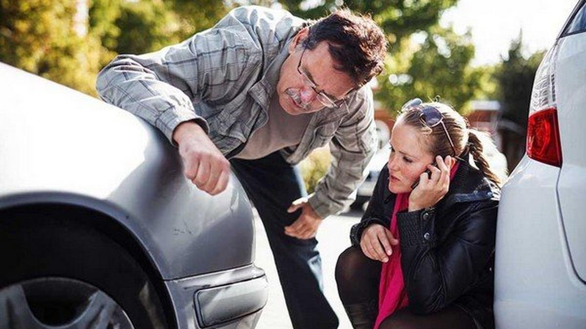 man and woman examine car