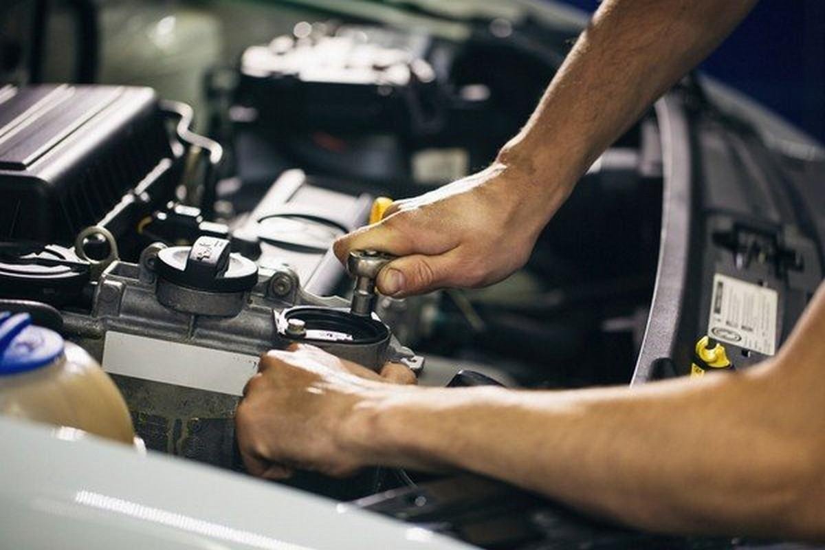 man repairing car bonnet