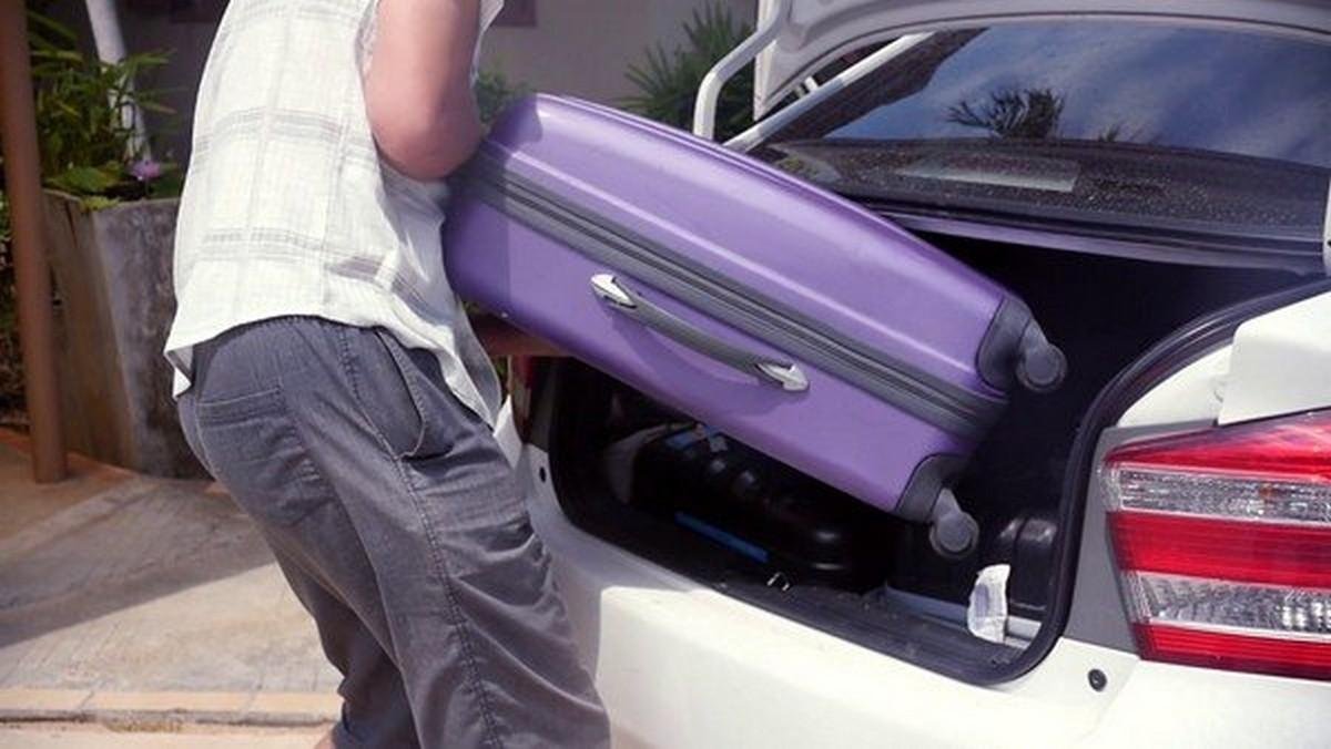 man take heavy suitcase from the car