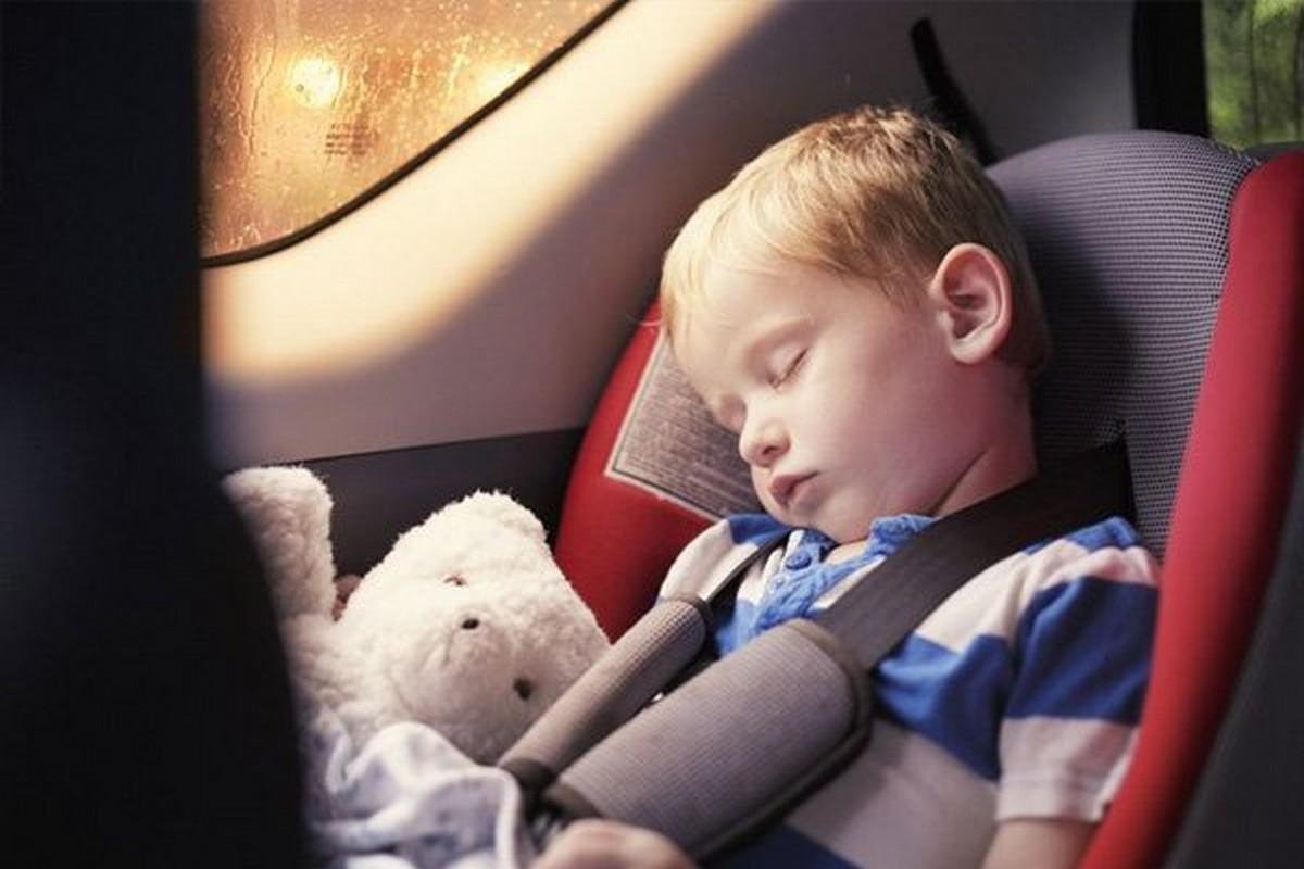 a child is sleeping at the back seat